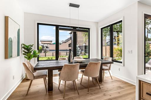 Dining nook just to the side of the kitchen encased by windows overlooking the private yard.