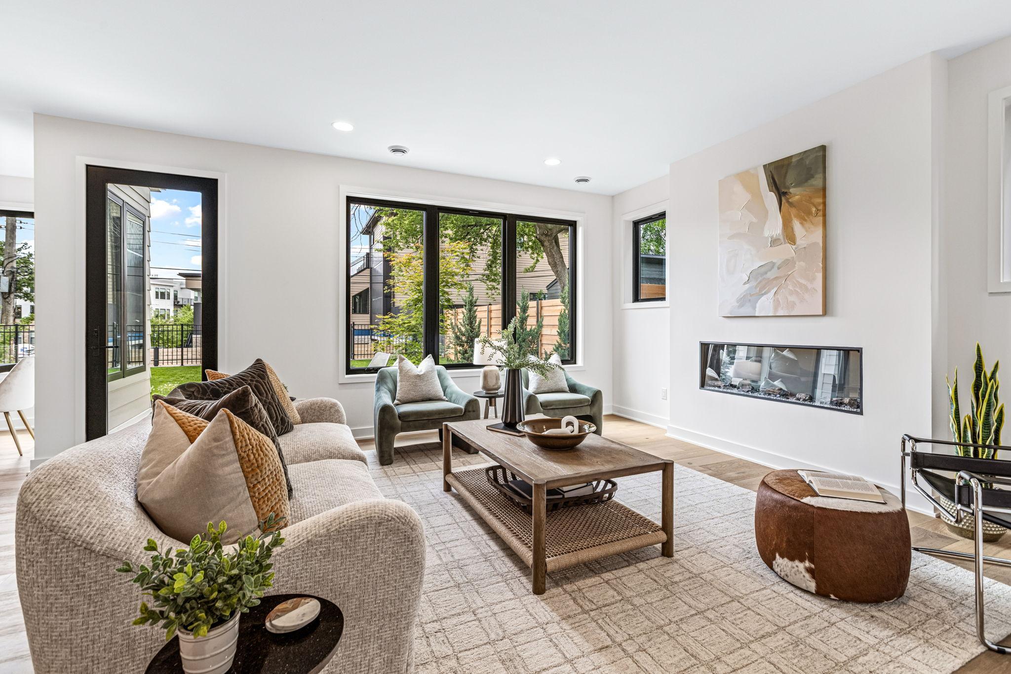 Nicely sized living room boasts walls of windows, a linear fireplace, and flows out to the patio and backyard.