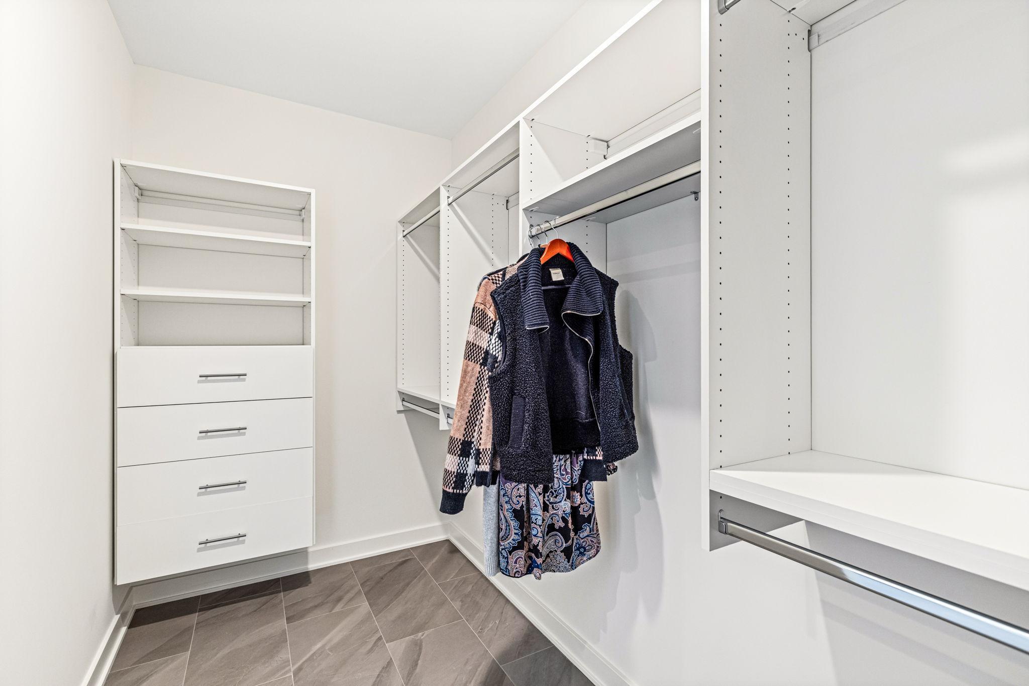 Walk-in primary closet with customized built-ins.