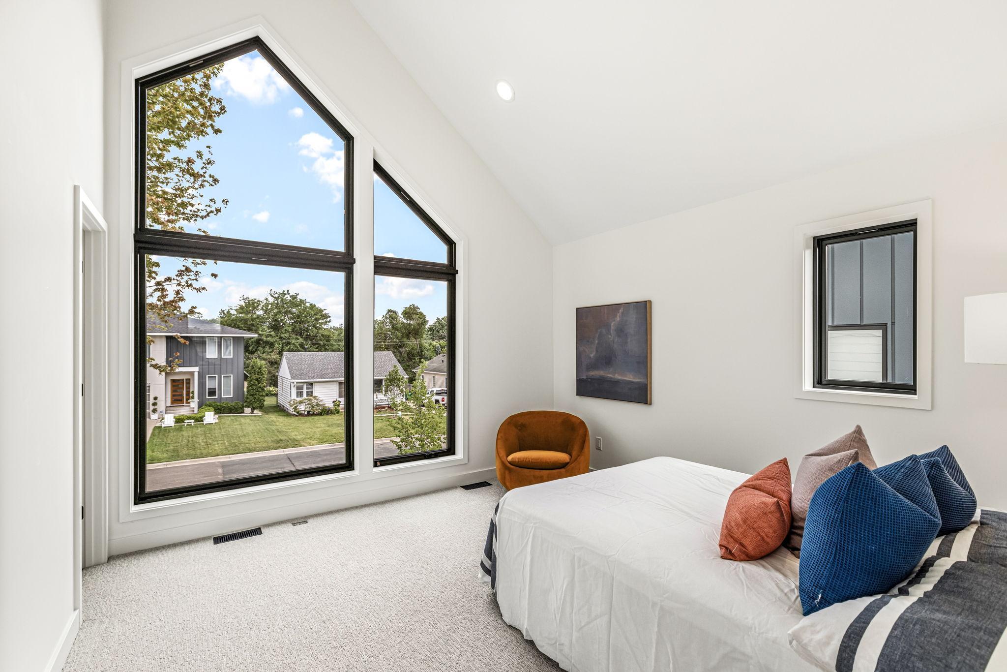 Secondary vaulted en-suite with incredible angled wall of glass and custom shades for privacy.
