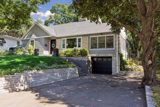 The recently constructed retaining wall is limestone and the driveway has been increased in width to accommodate two vehicles. The single car garage is extra deep for added storage