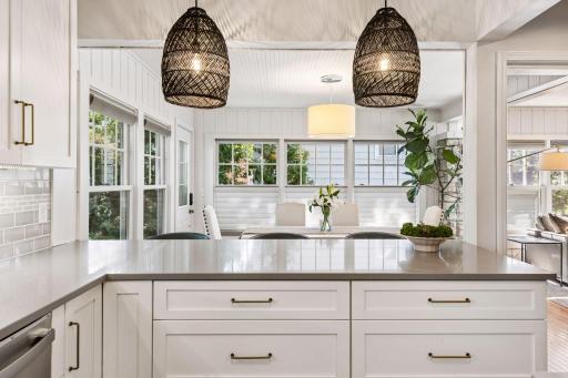 The open kitchen with quartz countertops and white cabinets are a pleasure to work and entertain in