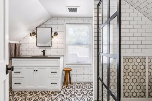 The upstairs ensuite bathroom with designer tile and a large walk-in shower