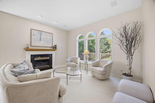 Formal living room with gas fireplace and large windows with round tops.