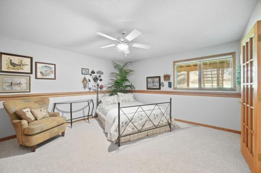 Lower level bedroom has daylight windows and a ceiling fan.