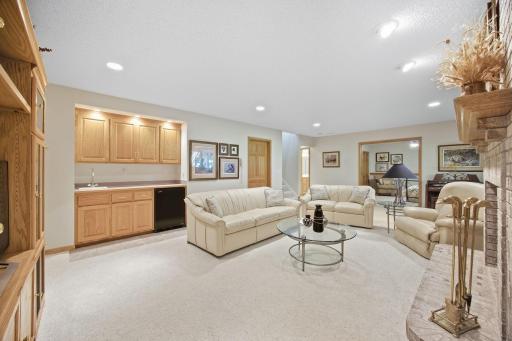 Wet bar has sink and small refrigerator with built in cabinetry.