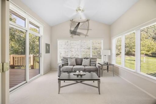 Sun room with 3 walls of windows and sliding door goes to deck.