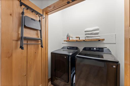 Convenient laundry closet off the main living area, with nearby walk-in storage and direct access to the attached three-car garage.