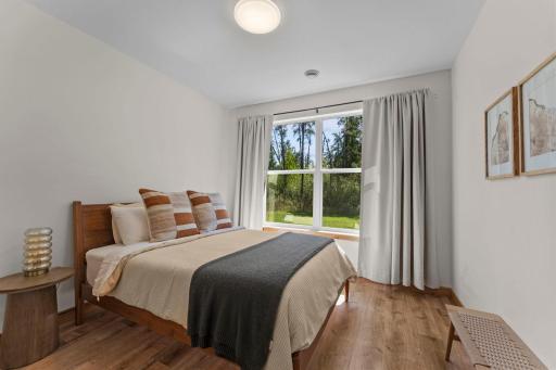 Third bedroom on the main level with a spacious walk-in closet and peaceful backyard views
