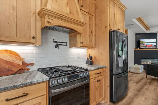 Stainless steel appliances complete the space featuring a gas range, creating a chef-inspired kitchen.