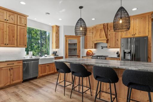 Oversized center island with statement lighting and comfortable counter seating.