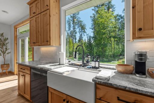 A stunning picture window with a view of the backyard from the sink.