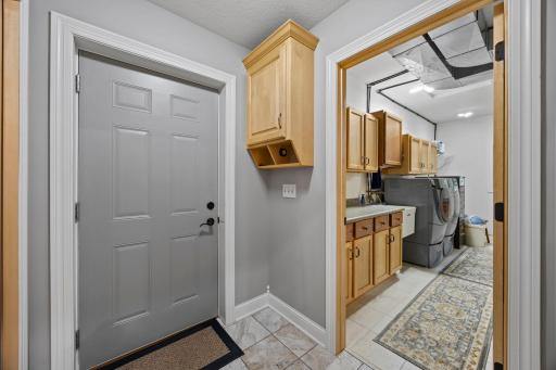 Garage entry with large closet & custom cabinet