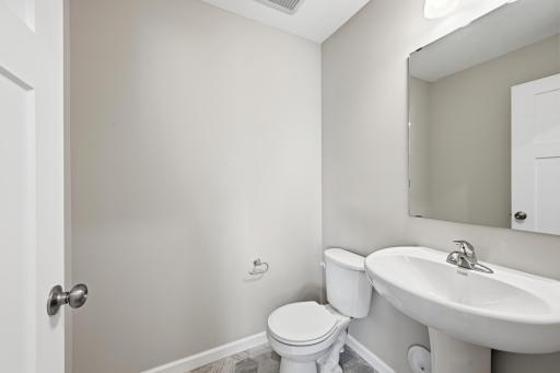 Conveniently tucked away powder bath on the main level. *photos of previously staged home, same floor plan and finishes however some features are not exact*