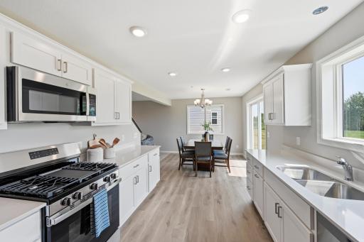 The kitchen flows directly into the dining and living spaces, so you'll never have to choose between hosting and being part of the conversation. *photos of previously staged home, same floor plan and finishes however some features are not exact*
