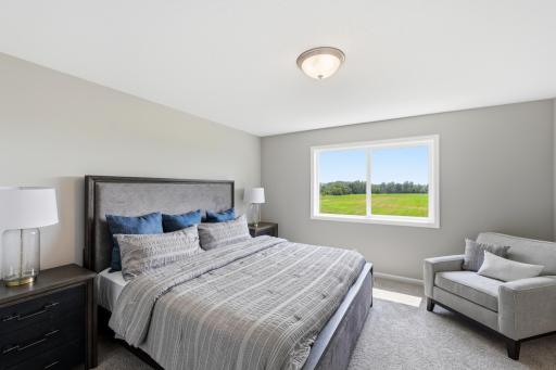 A spacious primary bedroom offers plenty of room to create a comfortable place to begin and end each day. *photos of previously staged home, same floor plan and finishes however some features are not exact*