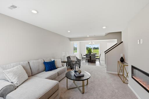 Open sightlines between the living room, dining area, and kitchen make the entire main level feel spacious and inviting. *photos of previously staged home, same floor plan and finishes however some features are not exact*