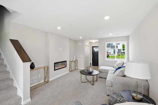 A cozy fireplace anchors the living room and creates the perfect spot for your sofa, favorite chairs, and evenings at home. *photos of previously staged home, same floor plan and finishes however some features are not exact*