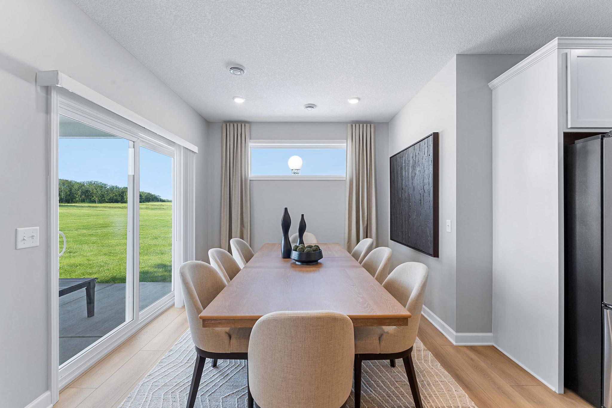 Situated in front of glass sliders, this dining room provides the perfect place for sun-dappled meals that can venture out to the covered patio.