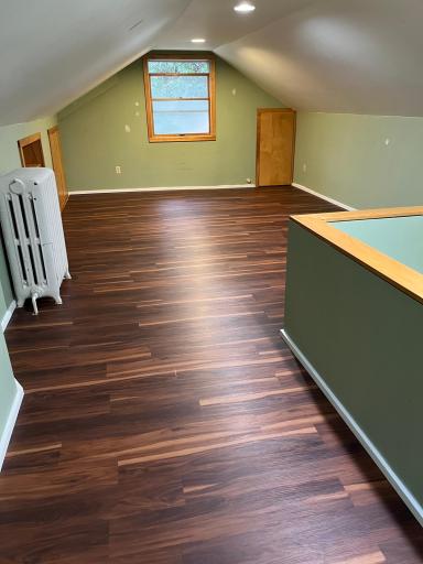 The upper level bedroom features brand new laminate flooring. Almost all of this area conforms to the 5 feet minimum ceiling height. This view is from the "foyer" area at the top of the stairs.