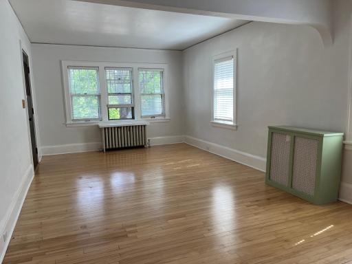 Bright and airy living room with maple flooring. The front entry is camera left.