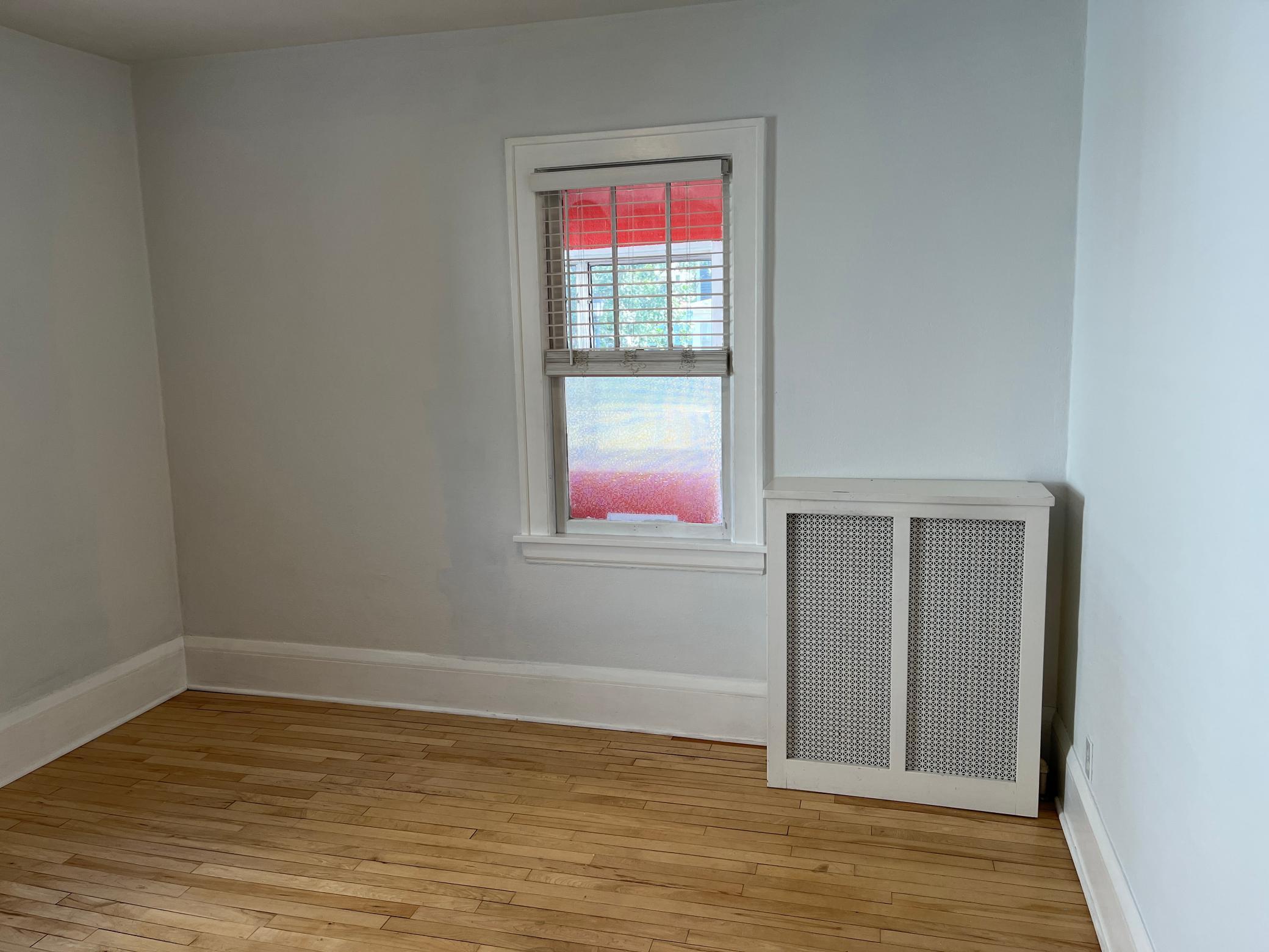 Main Level front bedroom. Three season front porch partially visible through the window.