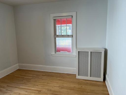 Main Level front bedroom. Three season front porch partially visible through the window.