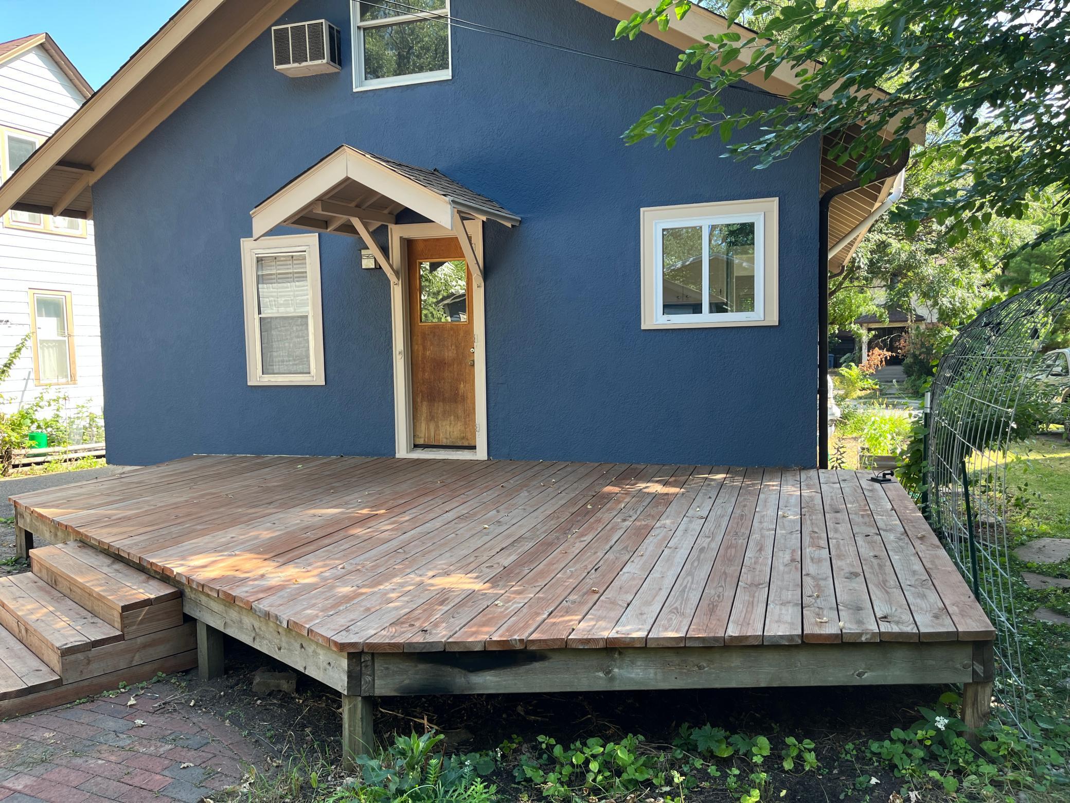 The deck measures 23 feet along the back of the house and, from camera left, comes out 8 feet, then turns on an angle to camera center 16 feet, from camera center the run is another 8 feet to the corner, then runs back to the house another 12 feet.