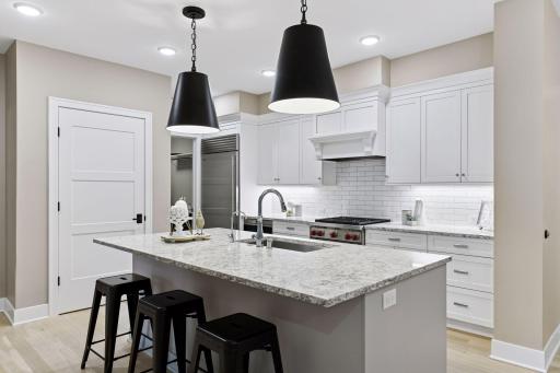 Kitchen features high-end SS appliances, center island, and tiled backsplash. Center island offers a casual breakfast bar for a quick bite to eat