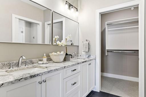 Primary bath with great counter and storage space, heated floors, and walk-in closet