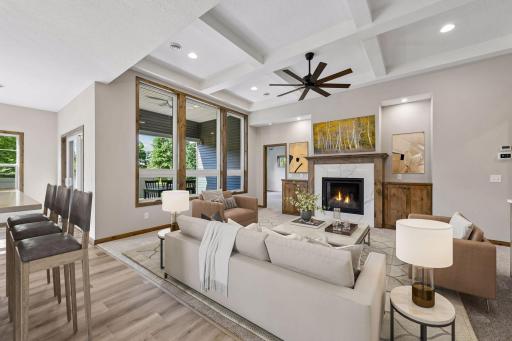 The vaulted living room showcases a coffered ceiling, large airy windows and a gas fireplace with ample built-ins.