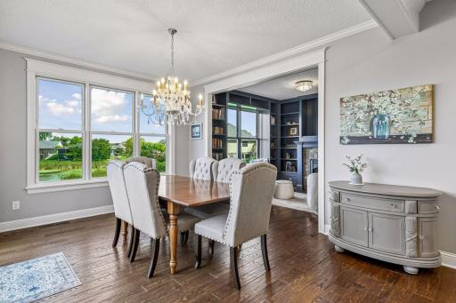 Enjoy elegant yet comfortable dining with picturesque views, abundant natural light, rich hardwood floors, and seamless flow to the living spaces. A perfect setting for everyday meals and memorable gatherings. Lovely hearth room is set off behind.