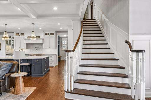A stunning staircase showcases rich hardwood treads, elegant millwork, and timeless craftsmanship, creating a grand transition to the upper level and setting the tone for the home's upscale design.