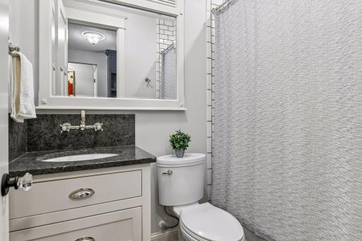 One of 5 bathrooms in the home which will impress! Full bathroom on main with milk glass tile surround and cast-iron tub, granite vanity with high end faucets as well carry the same quality and theme throughout all baths in the home.