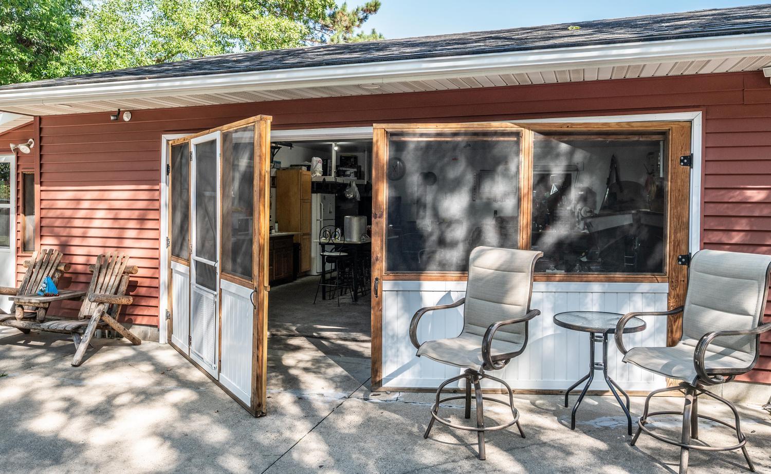 Custom screen door creates a comfortable, versatile space for everyday use, bringing in fresh air while keeping bugs out and providing easy access to the kitchen area.