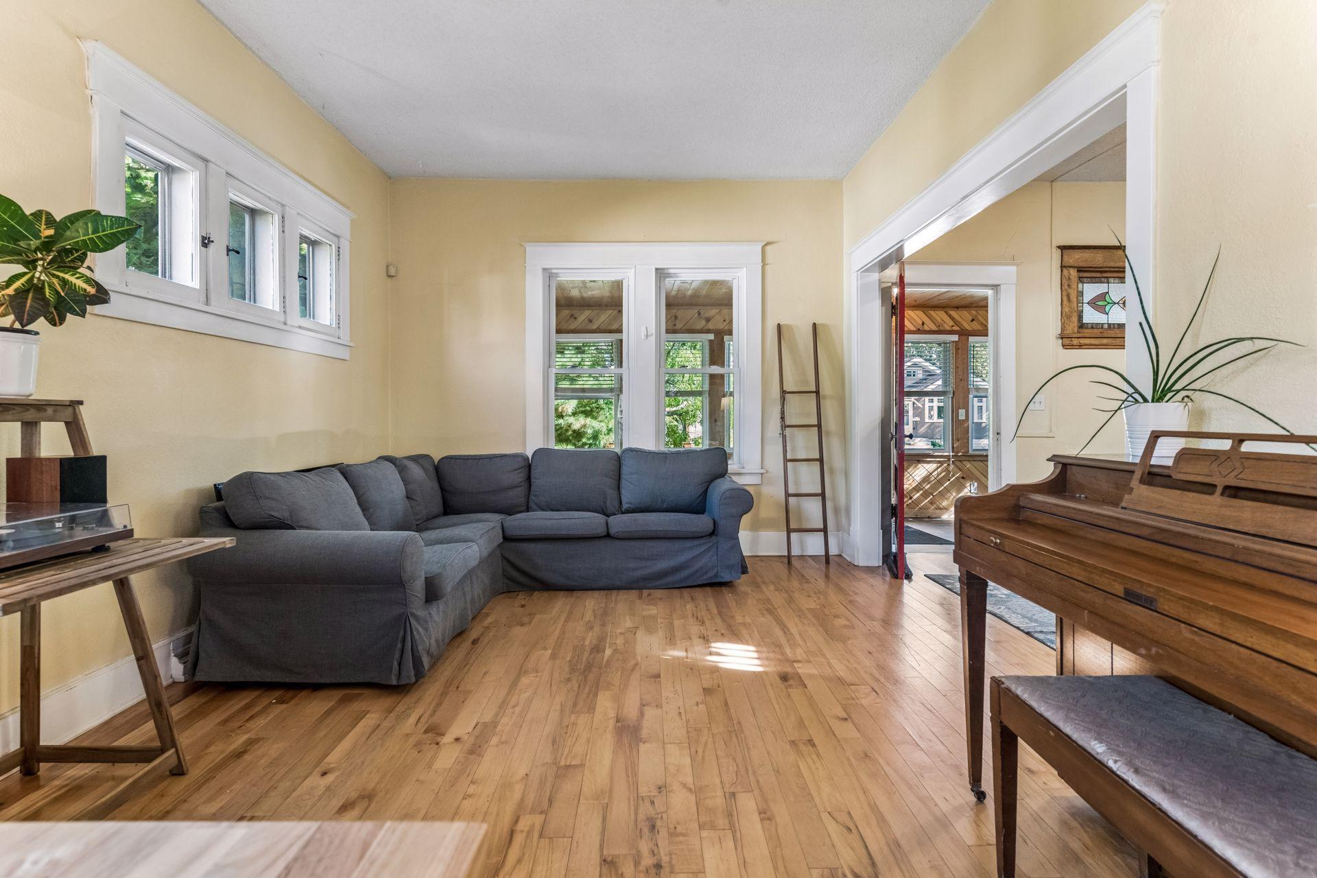 Light and airy, this inviting living room features classic white trim and windows overlooking the charming enclosed front porch. One of the many wonderful spaces to relax and enjoy an abundance of natural light.