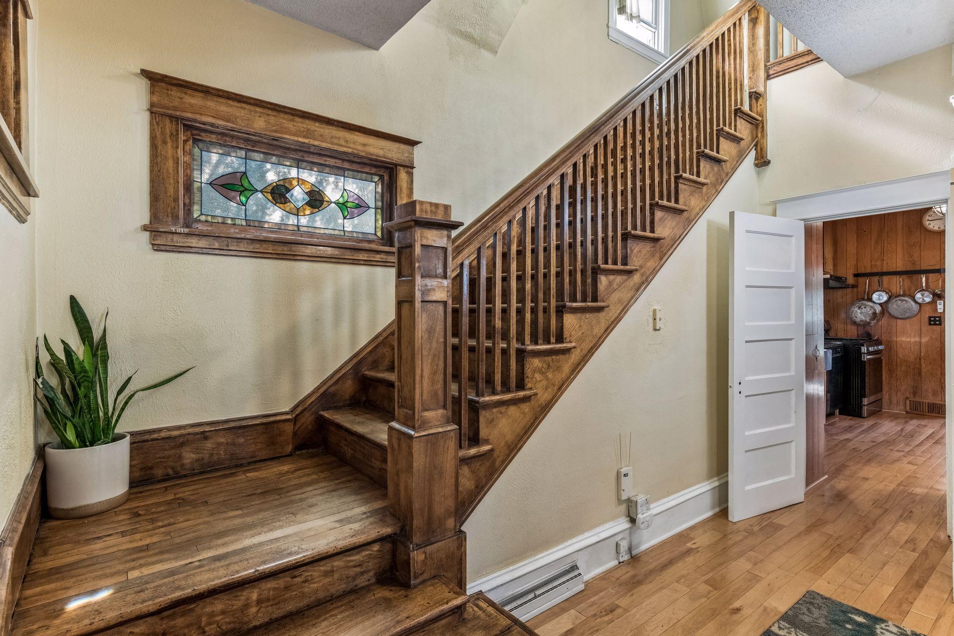 The home's original craftsmanship shines through in the beautifully detailed staircase, featuring a substantial square newel post and solid wood balusters.
