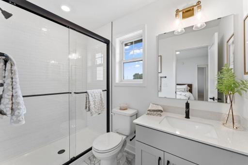 This bathroom is easily accessible from the main living area and bedroom 5, complete with a single vanity and glass-enclosed shower.