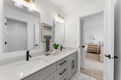 This Jack-and-Jill bathroom connects two bedrooms on the second floor, complete with dual sinks to accommodate seamless shared living.