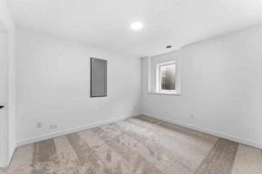 The laundry room is centrally located near the primary bedrooms on the top floor, with a sink and washer-dryer connections to streamline everyday chores.