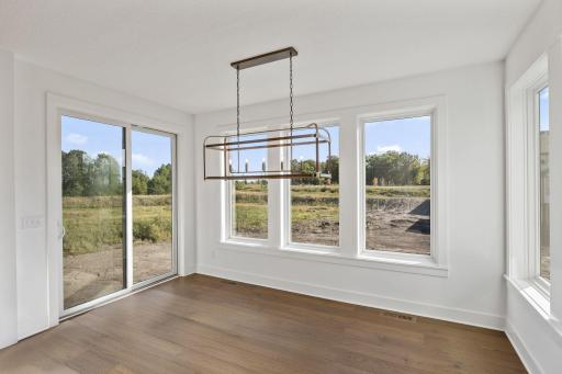 Large windows in the dining room brighten the space and create an airy atmosphere perfect for delicious meals. As itâs shown here, an optional porch is available to extend activities outside.