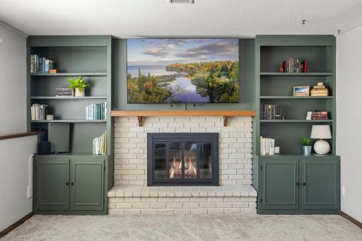 A second fireplace flanked by pretty bookshelves.