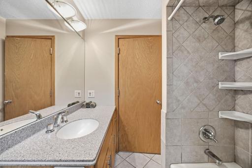29- Upper level full bath with Corian countertops and tile surround.