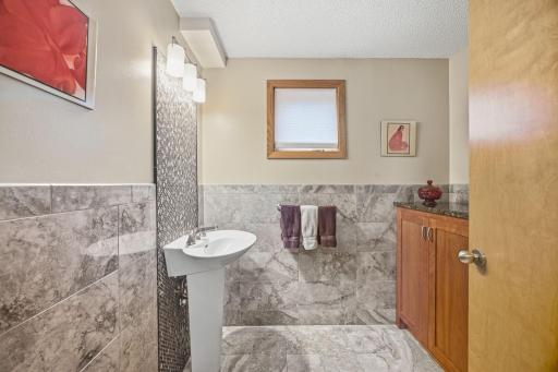 35- 1/2 bath off of the entry 1/2 wall tiling and built in cabinetry with granite top.