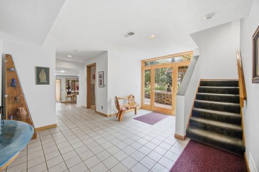 30- Tiled entry has full glass door with glass sidelights and transom flooding entry with natural light.