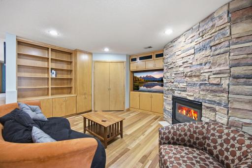 Entertaining made easy with a stone fireplace, wet bar, wine fridge, and sliding door to the pool retreat