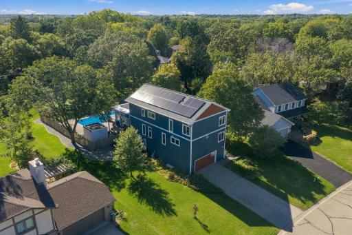 Birds eye view showcases the solar panels and fenced yard with peak at pool shed and cedar fenced pool area.