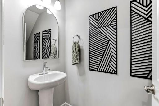 Beautifully decorated main-floor half bath, conveniently located for guests.