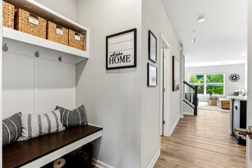Convenient drop zone off the garage with a built-in bench, hooks, and extra storage.