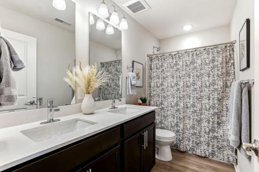 Full upper-level bathroom with double sinks, plenty of counter space, and a tub/shower.